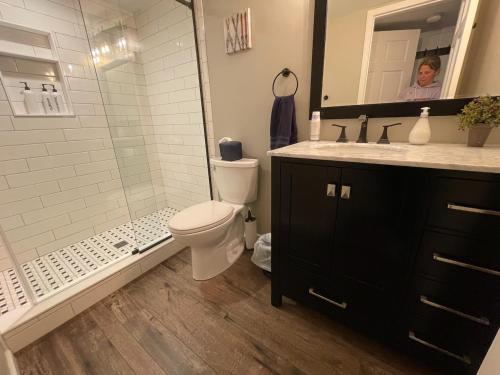 a bathroom with a toilet and a shower and a sink at SKI Bike, Hike & Golf Townhouse w/ Hot tub in Ellicottville