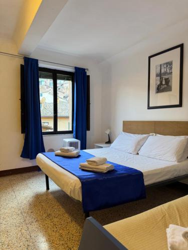 a bedroom with a bed with blue sheets and a window at Gest Short Rent Siena 3 in Siena
