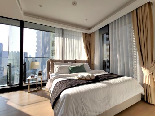 a bedroom with a large bed and a large window at Sukhumvit 11#Luxury#Pool#Gym#BTS Nana&MRT Sukhumvit#1BR#Max2ppl in Bangkok