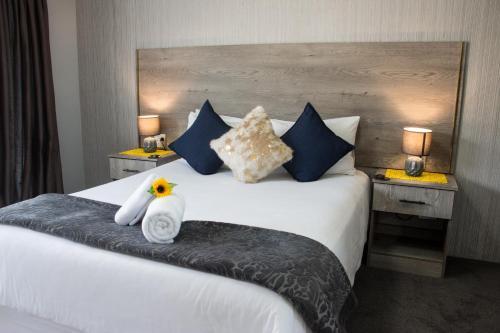 a hotel room with a bed with two stuffed animals on it at McAllisters on 8th in Durban