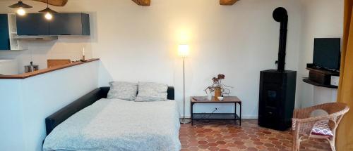 a small bedroom with a bed and a table at Le Grenier in Saint-Christophe-sur-Condé