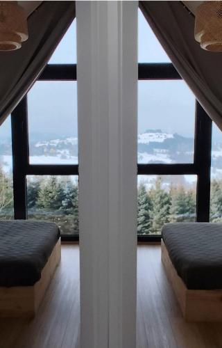 a room with two beds and large windows at Wśród Gór in Istebna