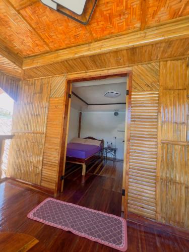 a room with a door to a bedroom with a bed at Aviniel Cottage in Puerto Galera