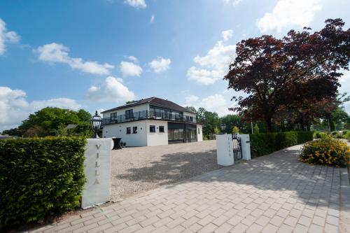 a large white house with a fence in front of it at Boutique Hotel Villa Elise in Winterswijk