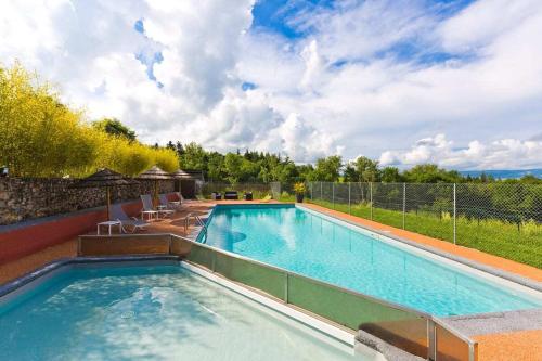 a swimming pool with chairs and a fence around it at Domaine Le Prieuré in Chaumont-le-Bourg