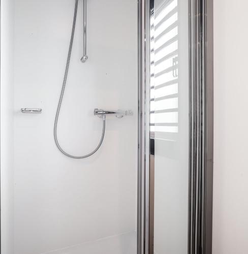 a bathroom with a shower with a glass door at de Valreep - Paviljoenwei 4 Offinga in Offingawier