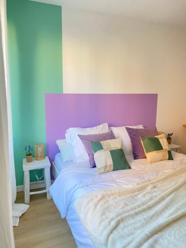 a bedroom with a large bed with a purple headboard at Casita Valence - Petite maison de charme - Parking gratuit & Jardin Privé in Valence