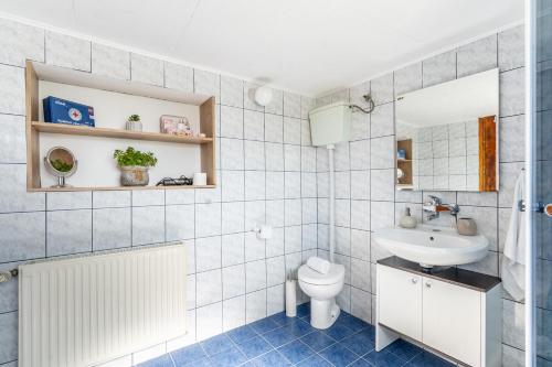 a bathroom with a white sink and a toilet at Apartman Suman in Vukovar