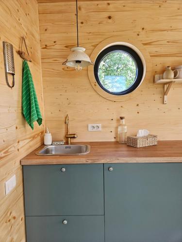 a kitchen with a sink and a round window at Retezat83 Sunshine tiny home , adults only in Râu de Mori