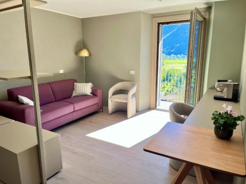 ein Wohnzimmer mit einem lila Sofa und einem Tisch in der Unterkunft Ca' di Av in Berbenno di Valtellina