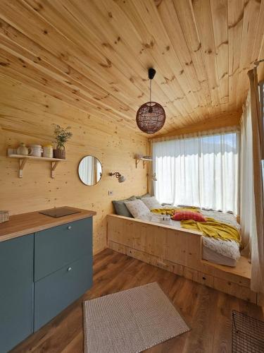 a bedroom with a bed in a wooden cabin at Retezat83 Sunshine tiny home , adults only in Râu de Mori