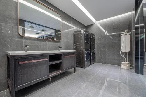 a bathroom with a sink and a mirror at Maihao Hotel in Rujiazhuang