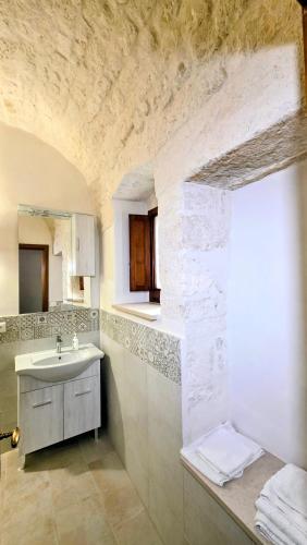 a white bathroom with a sink and a counter at il trullo di giada e mattia in Alberobello