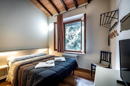 a bedroom with a bed and a window at Locanda il Boschetto in Volterra
