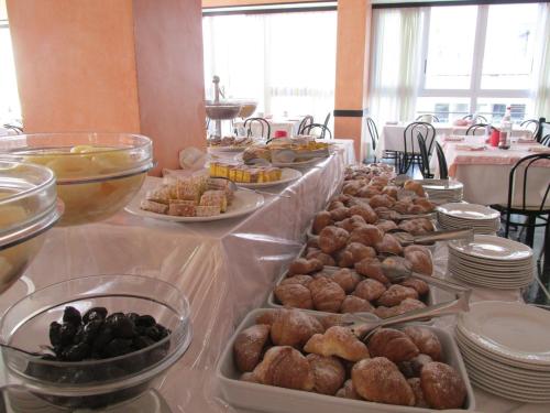 a table with several trays of different types of food at Hotel London in Cattolica