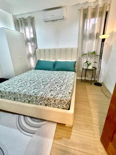a bedroom with a bed with blue pillows at Qagayon Homestay in Sampong