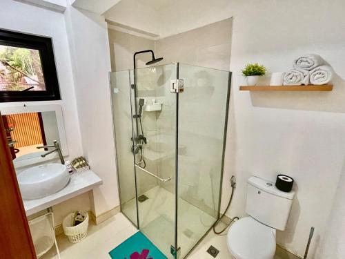 a bathroom with a shower and a toilet and a sink at Qagayon Homestay in Sampong