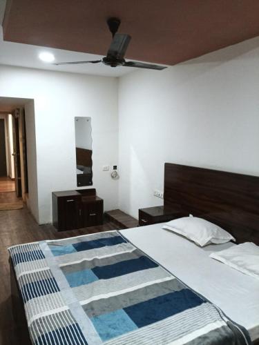a bedroom with a bed and a ceiling fan at Hotel HV Palace in Bhuj