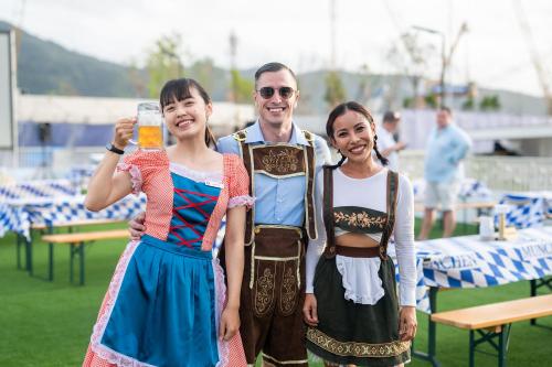 a man and two girls are holding a glass of beer at HOMA Cherngtalay Phuket in Bang Tao Beach