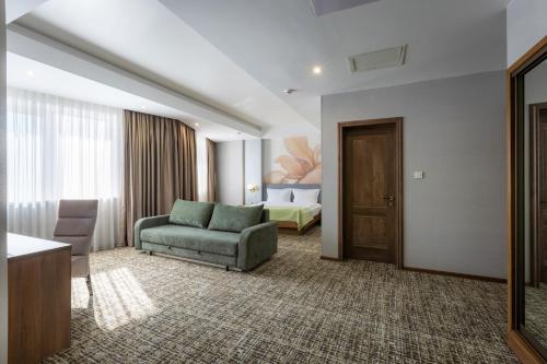 a hotel room with a couch and a bedroom at Renion Hills Hotel in Almaty