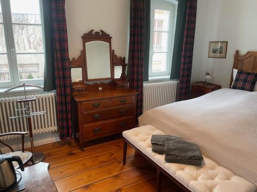 a bedroom with a bed and a dresser and a mirror at B&B Fiddler's Inn in Neuruppin
