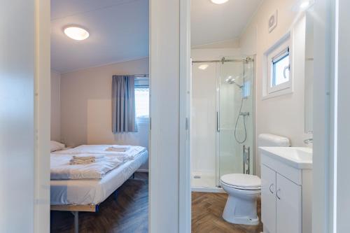 a bathroom with a bed and a shower and a toilet at Duinhoeve chalet Schelp in Burgh Haamstede