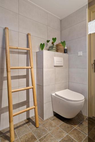a bathroom with a toilet and a shelf with plants at Boshuisje met privétuin bij Kruisbergse bossen Achterhoek in Hummelo