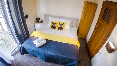 a bedroom with a large bed with yellow and blue sheets at Villa Amber in Sarbinowo