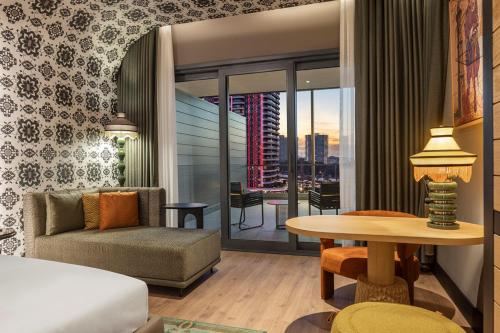 a hotel room with a bed and a table with a couch at Canopy By Hilton Izmir Bomonti in İzmir