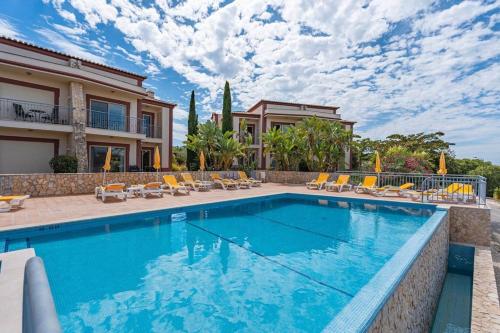 a swimming pool in front of a house at Vale Da Pinta Golf Resort in Carvoeiro