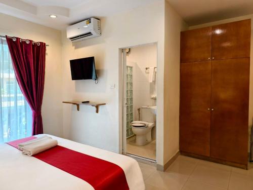 a bedroom with a bed and a bathroom with a toilet at Zing Resort & Spa in Pattaya South