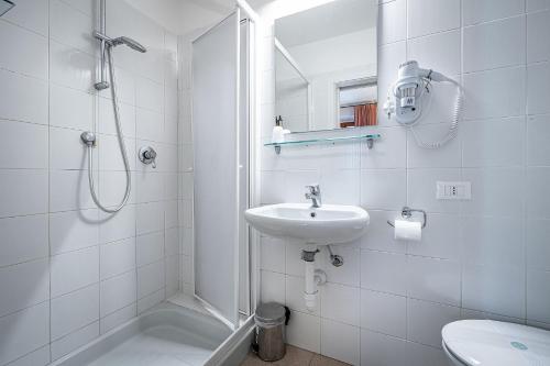 a white bathroom with a sink and a shower at Locanda il Boschetto in Volterra
