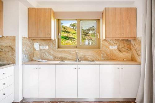 a kitchen with a sink and a window at Chrisselen Stalos in Chania