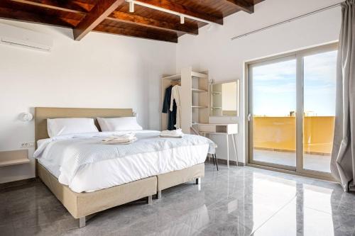 a bedroom with a large bed and a large window at Chrisselen Stalos in Chania