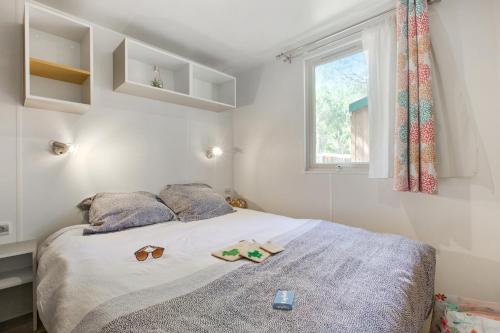 a bedroom with a bed with two slippers and a window at Camping Groene Eiland in Appeltern