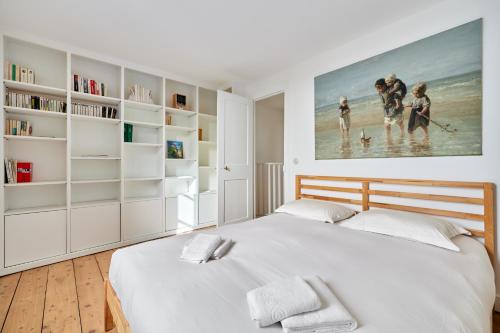 a bedroom with a bed and a large painting on the wall at Les Volets Bleus de Trouville - Centre - Plage in Trouville-sur-Mer