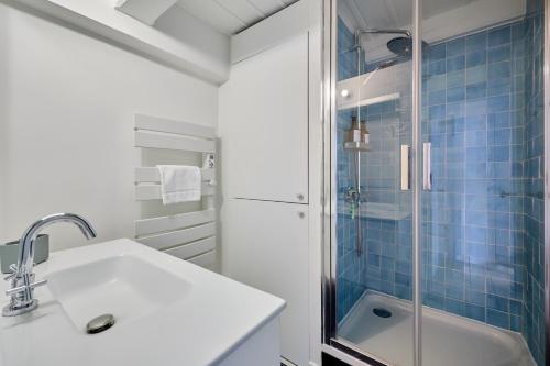a bathroom with a sink and a shower at Les Volets Bleus de Trouville - Centre - Plage in Trouville-sur-Mer