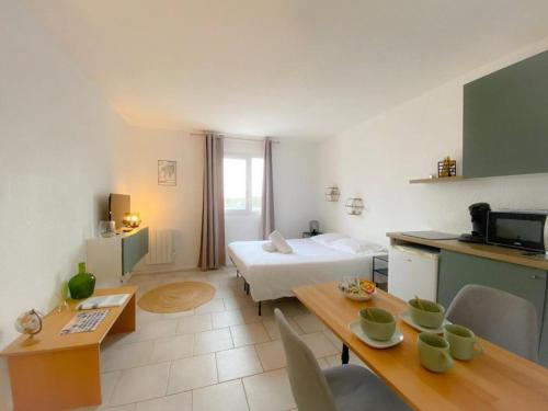 a room with a bed and a kitchen with a table at Studio - Plage de Calais - Skatebeach in Calais