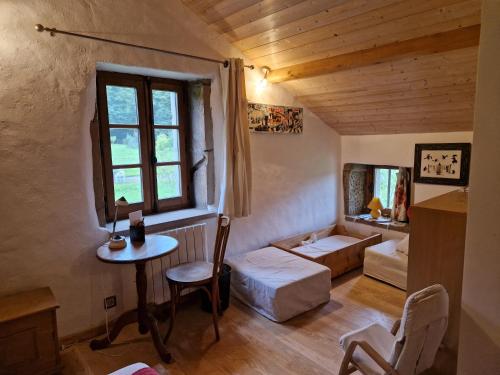 a room with a bed and a table and a window at La Cabiole in Claudon