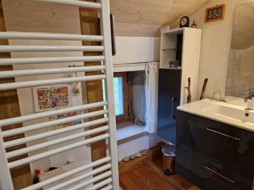 a small bathroom with a sink and a window at La Cabiole in Claudon