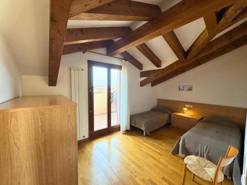 a bedroom with a bed and a window and wooden floors at Stella Marina in Grado