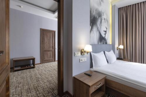 a bedroom with a bed with a black and white picture at Renion Hills Hotel in Almaty