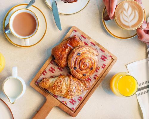 a table with a plate of pastries and a cup of coffee at Radisson RED London Twickenham in Twickenham