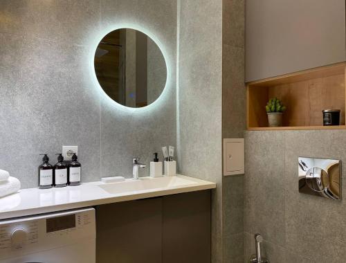 a bathroom with a sink and a mirror at Alma Park in Taldykolʼ