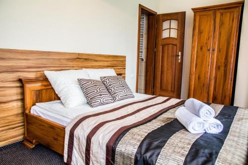 a bedroom with a bed with two towels on it at Villa Amber in Sarbinowo