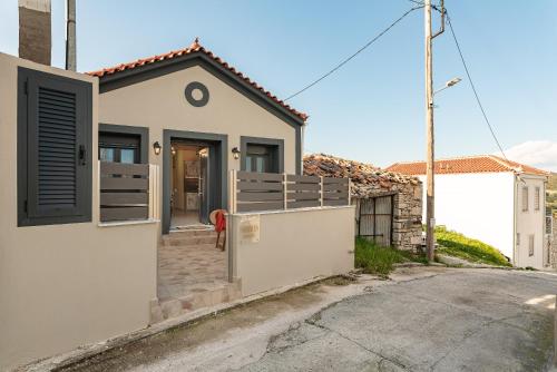 a white house with a gate and a driveway at Sirius House in Mytilinioí