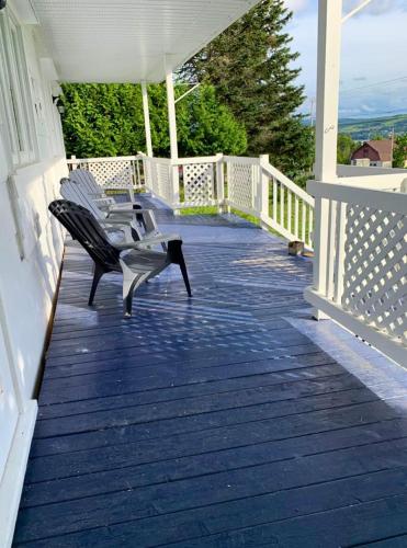 a bench sitting on the porch of a house at La Villa Rustique-2 in Notre-Dame-du-Lac
