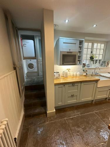 a kitchen with a sink and a washing machine at Little Monmouth 4 bedroom cottage, Old town Lyme Regis, dog friendly and parking in Lyme Regis