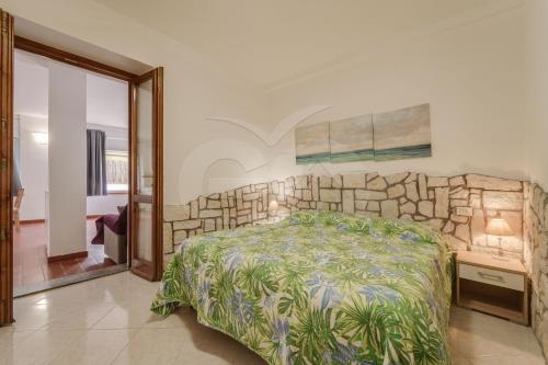 a bedroom with a bed and a stone wall at Azzurro Mare a Seccheto - Goelba in Seccheto
