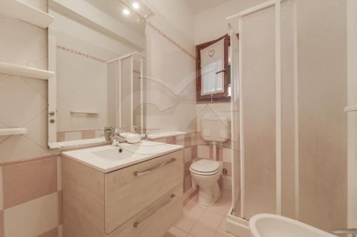 a white bathroom with a sink and a toilet at Azzurro Mare a Seccheto - Goelba in Seccheto